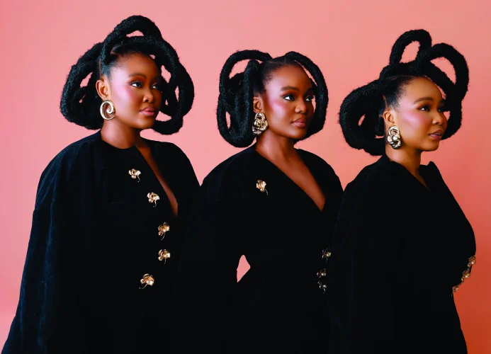 The sisters in profile against a pink backdrop