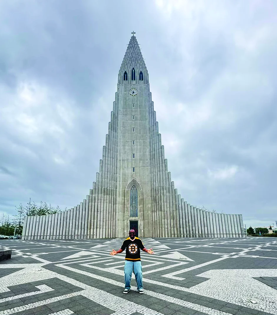 WakaWaka Doctor with arms outstretched in front of Hallgrímskirkja, Reykjavík