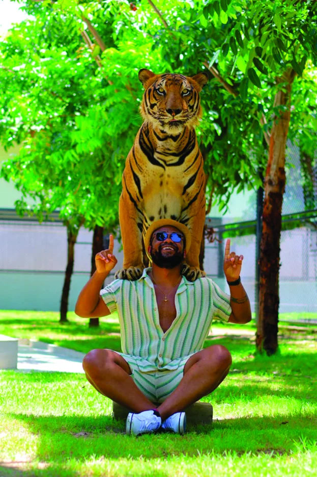 WakaWaka Doctor posing beneath a tiger statue
